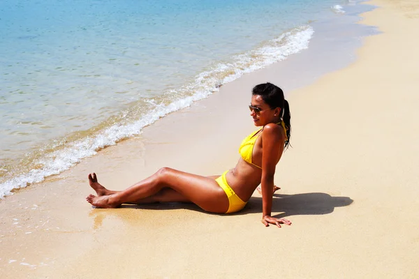 Nuori nainen aurinko kylpee hiekkarannalla Thaimaassa — kuvapankkivalokuva