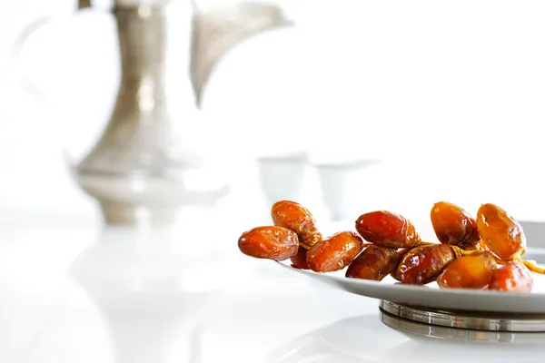 Arabic dates on a plate with Arabic coffee pot of the Bedouin — Stock Photo, Image