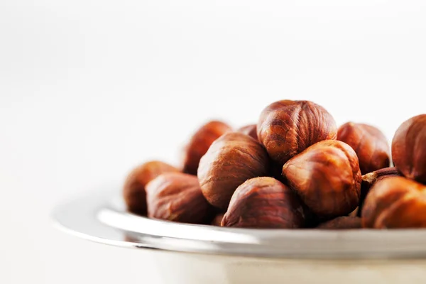 A bowl of hazelnuts on a white background — Stock Photo, Image