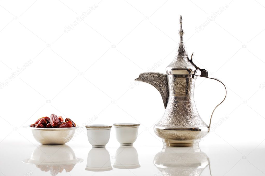 A dallah, a metal pot for making Arabic coffee with a bowl of dried dates