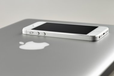 Beyaz iphone 5 döşeme üzerinde kapalı bir kapak apple MacBook pro dizüstü bilgisayar