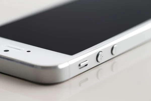Новый белый смартфон на белом отражающем фоне — стоковое фото