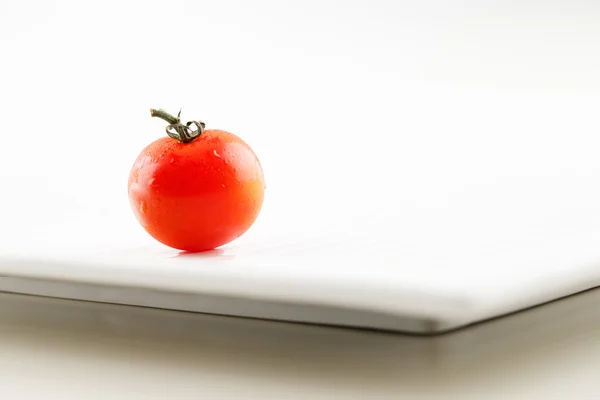 Een verse organische tomaat met waterdruppeltjes — Stockfoto