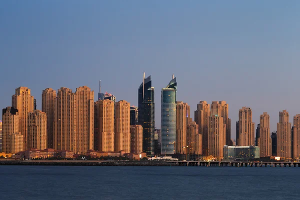 Dubai marina i skymningen sett från palm jumeirah i dubai, Förenade Arabemiraten Royaltyfria Stockfoton