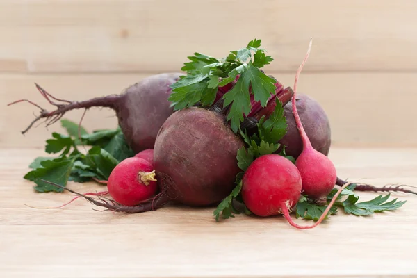 beets, radishes and herbs on a wooden background