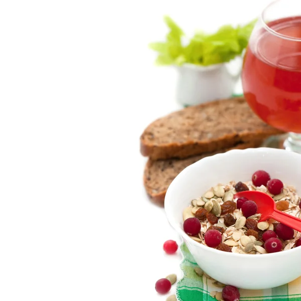 Ontbijt met huisgemaakte muesli en bessen, pompoenpitten, cranberry sap, brood geïsoleerd op witte achtergrond Stockfoto