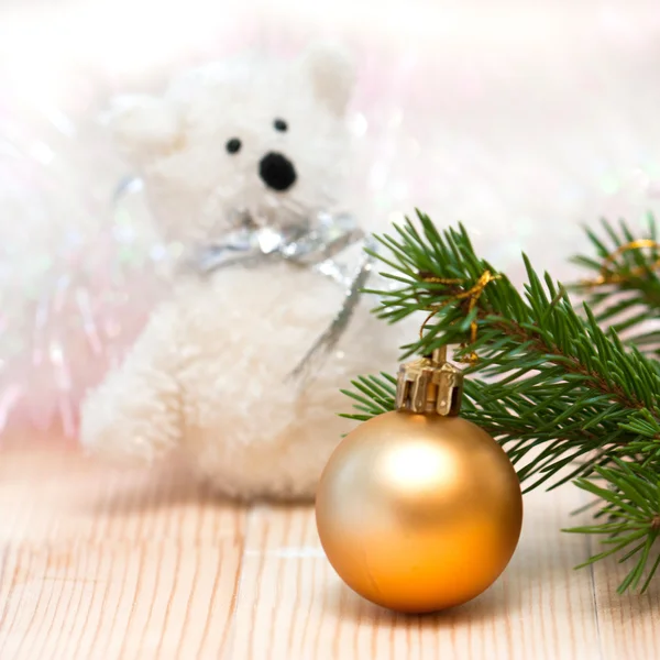 Toy polar bear and an orange ball on the Christmas tree — Stock Photo, Image