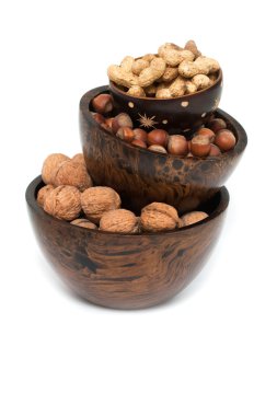 beyaz zemin üzerinde bir ahşap kase fındık