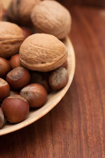 Орехи в деревянной чаше на коричневом фоне — стоковое фото