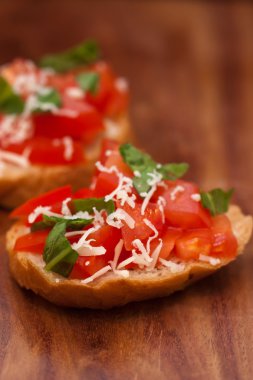 ahşap tahta üzerinde Bruschetta ızgara ciabatta, zeytin yağı, doğranmış domates, sarımsak ve maydanoz yaprakları