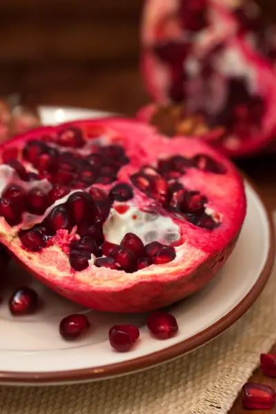 Pomegranate on wooden board — Stock Photo, Image