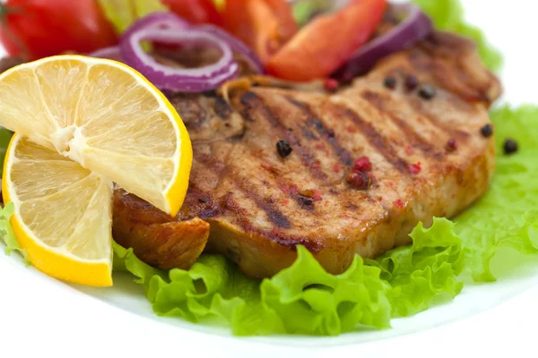 Gegrild vlees steak met kruiden en tomaten, ui, peper, citroen, geïsoleerde op witte achtergrond — Stockfoto
