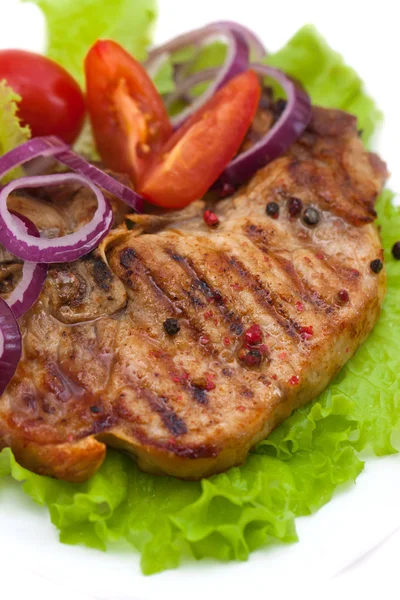 Gegrild vlees steak met kruiden en tomaten, ui, peper, citroen, geïsoleerde op witte achtergrond Stockfoto