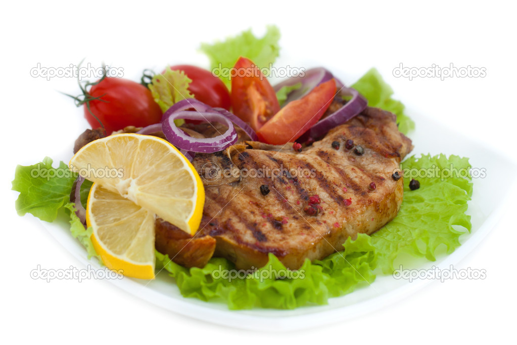 Grilled meat steak with herbs and tomatoes, onion, pepper, lemon