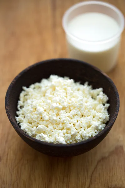 Cottage cheese in a wooden bowl and milk — Stock Photo, Image