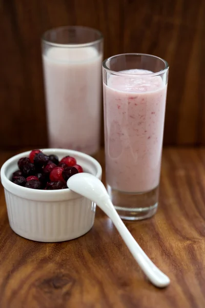 Strawberry smoothie and berries in a bowl on a wooden background — Stock Photo, Image