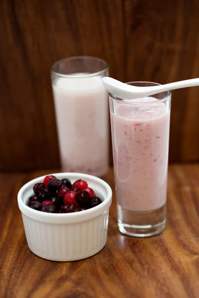 Strawberry smoothie and berries in a bowl on a wooden background — Stock Photo, Image