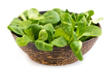 ahşap kase mısır salata yaprakları, beyaz zemin üzerine izole