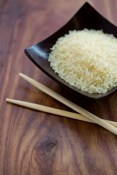 Wooden bowl with rice and Chinese chopsticks — Stock Photo, Image