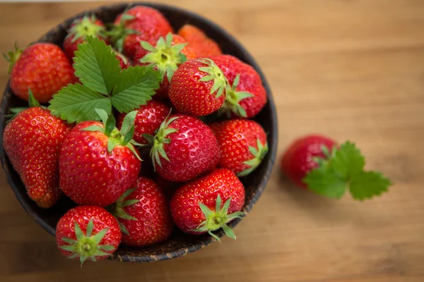 Verse aardbeien in een houten kom op een houten achtergrond Rechtenvrije Stockafbeeldingen