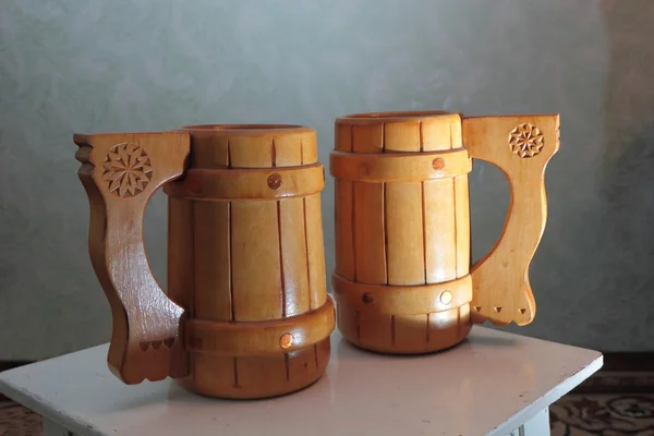 Dos tazas de madera en un taburete . — Foto de Stock