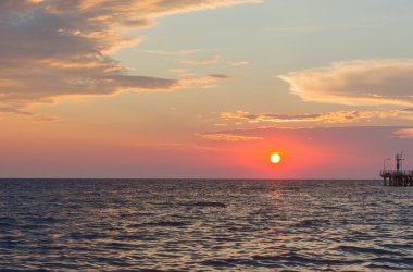 Denizin üzerinde gün batımı.