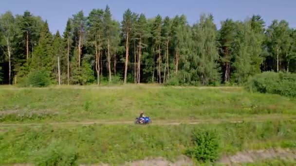 Een jongeman rijdt op een motor buiten de stad. Drone — Stockvideo