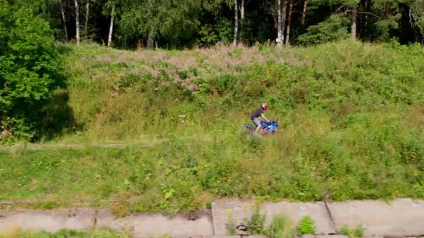 Un ragazzo guida una moto fuori città. Drone — Video Stock
