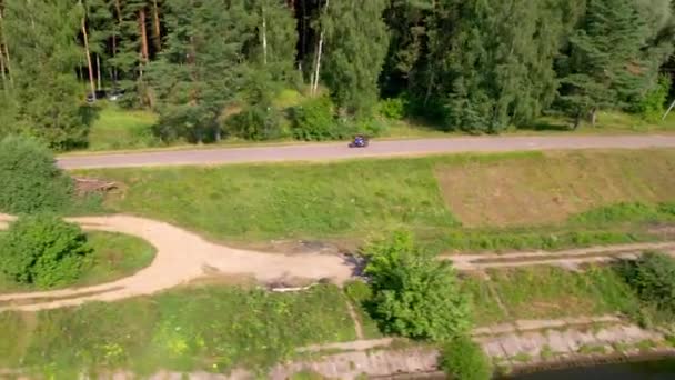 Seorang pemuda mengendarai sepeda motor di luar kota. Drone — Stok Video