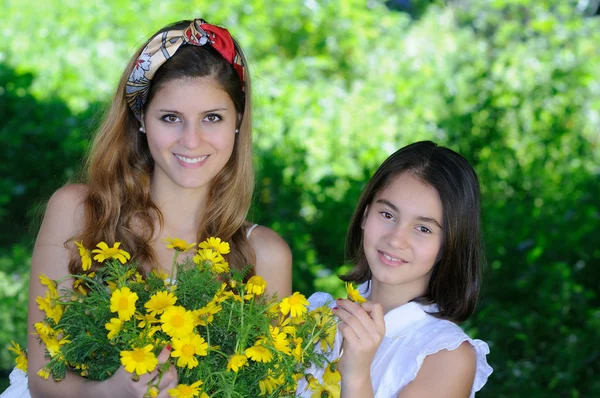 Two sisters with daisies — Stock Photo, Image