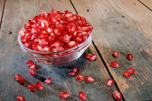 Pomegranate seeds on an wodden board — Stock Photo, Image