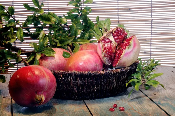 Pomegranates on an old wooden board — Stock Photo, Image