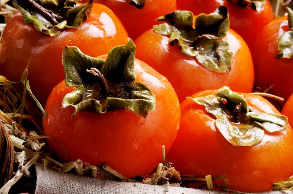 Wicker basket full of persimmons fruits — Stock Photo, Image