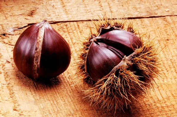 Chestnuts on wood table — Stock Photo, Image