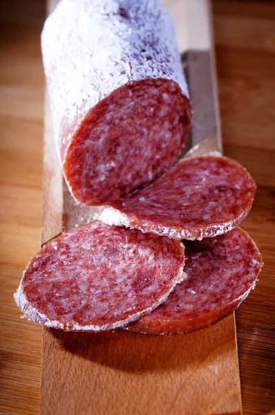 Seasoned salami on chopping board — Stock Photo, Image