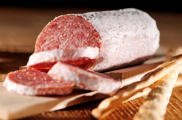 Seasoned salami on wood — Stock Photo, Image