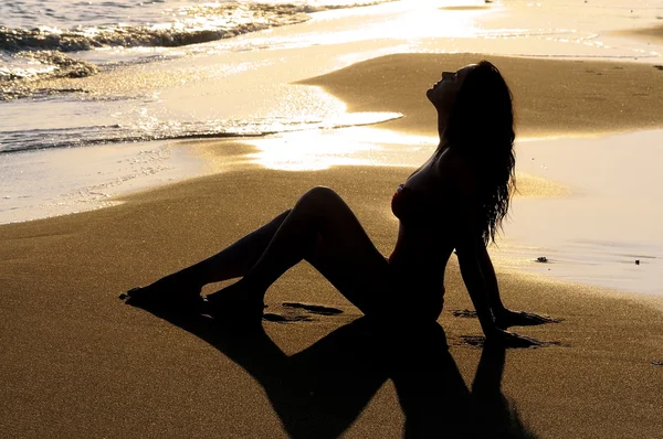 Женщина сидит на песке — стоковое фото