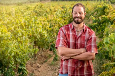 Üzüm bağında kendine güvenen genç bir çiftçi.