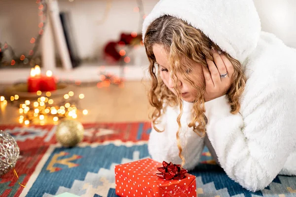 Noel atmosferinde Noel hediyesi olan genç sarışın kız.