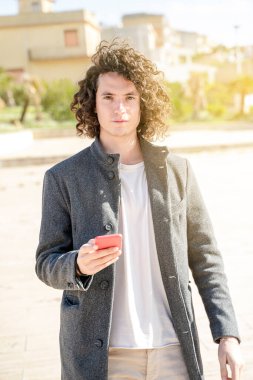 Yakışıklı genç adam, kameraya doğrudan telefonla bak.