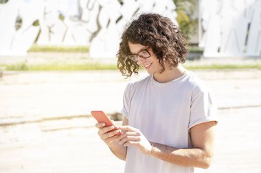 Cep telefonu olan yakışıklı bir genç adam.