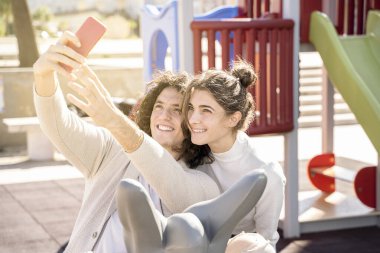 Genç çift halk parkında fotoğraf çekmekten zevk alıyor.