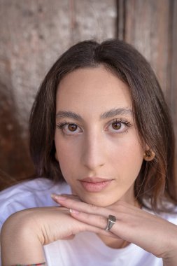 Şehirde oturan düz kahverengi saçlı şirin bir kızın portresi.