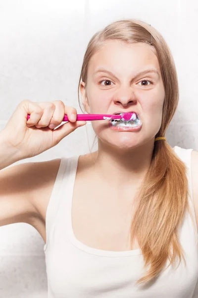 Ung flicka är att rengöra tänderna — Stockfoto