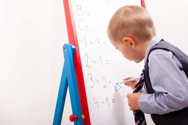 Pak kleine jongen werken op het schoolbord — Stockfoto