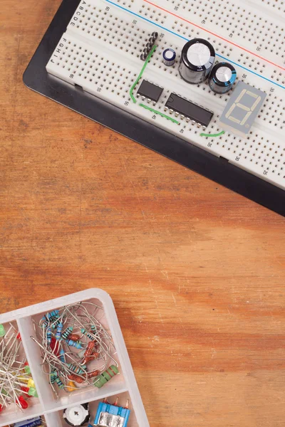 Electrical circuit on breadboard on dirty wooden background — Stock Photo, Image