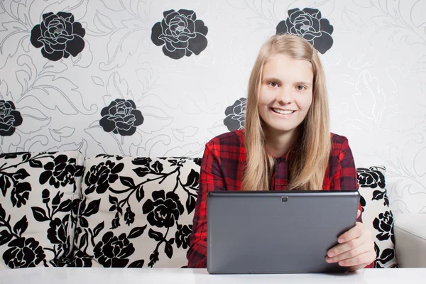 Usmívající se dospívající pracuje na tabletu a posezení přední části f — Stock fotografie