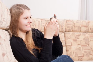 oturma odasında kanepede otururken cep telefonu ile mutlu teen