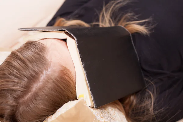 Adolescente deitado dormindo no sofe com livro em seu rosto — Fotografia de Stock