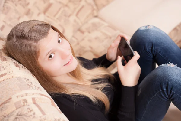 oturma odasında kanepede otururken cep telefonu ile mutlu teen